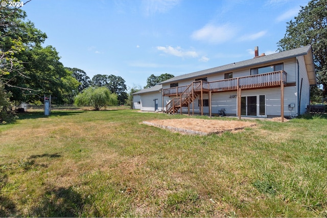 rear view of property with a wooden deck and a yard