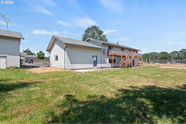 rear view of property with a deck and a lawn