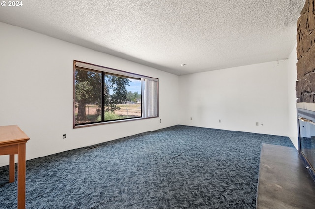 carpeted empty room with a textured ceiling