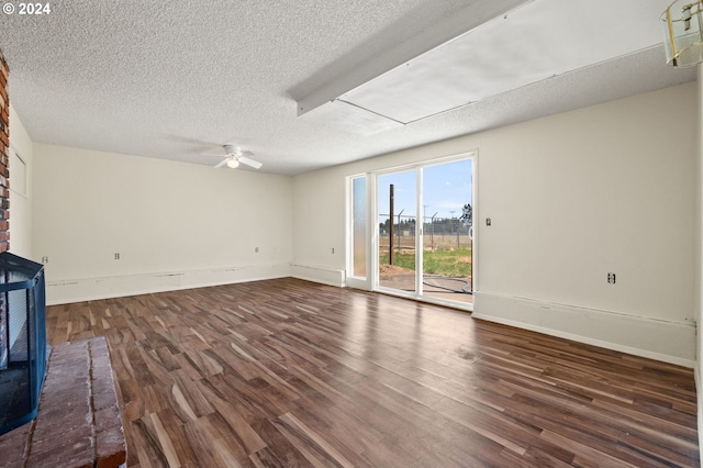 unfurnished living room featuring ceiling fan, dark hardwood / wood-style floors, and a textured ceiling