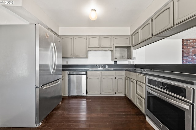 kitchen with dark wood-type flooring, sink, gray cabinetry, and stainless steel appliances