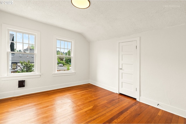 5125 NE Davis St, Portland, OR 97213 - spare room with wood-type flooring, a textured ceiling, baseboards, and lofted ceiling