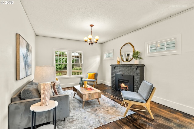 5125 NE Davis St, Portland, OR 97213 - living area featuring dark wood-style floors, a chandelier, a brick fireplace, a textured ceiling, and baseboards
