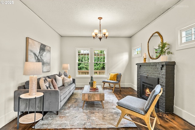 5125 NE Davis St, Portland, OR 97213 - living room with a chandelier, a textured ceiling, dark wood-type flooring, a brick fireplace, and baseboards