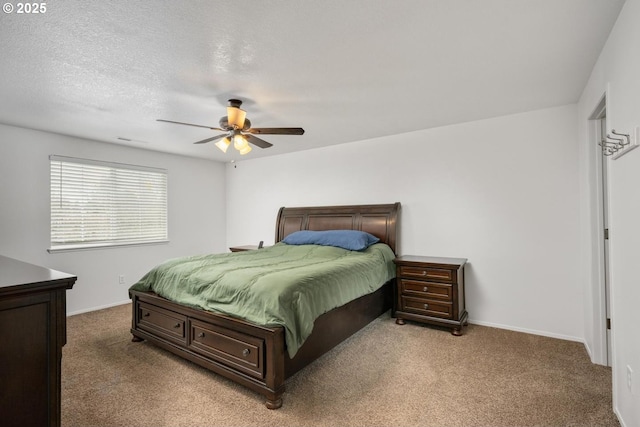 bedroom with a ceiling fan, light colored carpet, baseboards, and a textured ceiling