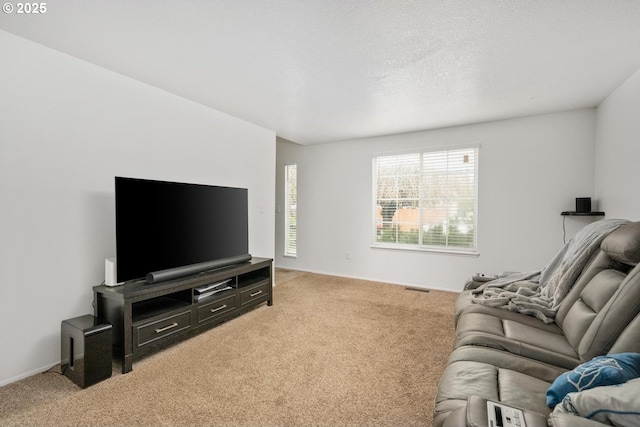 living room with light carpet, visible vents, and a textured ceiling