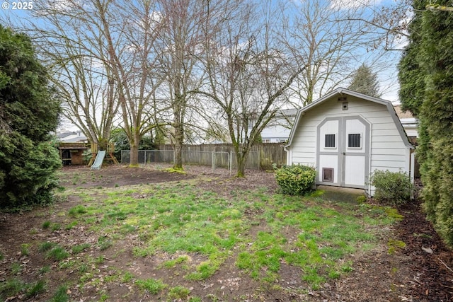 view of yard with a shed, an outdoor structure, and fence