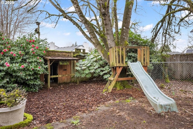 view of play area featuring an outdoor structure and fence