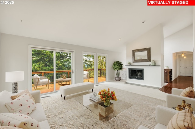 1610 Lee St, Lake Oswego, OR 97034 - living room featuring arched walkways, a fireplace, wood finished floors, and high vaulted ceiling