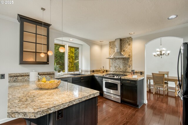 1610 Lee St, Lake Oswego, OR 97034 - kitchen with appliances with stainless steel finishes, wall chimney exhaust hood, light countertops, arched walkways, and ornamental molding