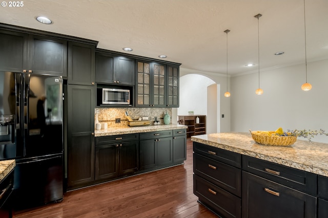 1610 Lee St, Lake Oswego, OR 97034 - kitchen featuring black refrigerator with ice dispenser, stainless steel microwave, arched walkways, backsplash, and light countertops