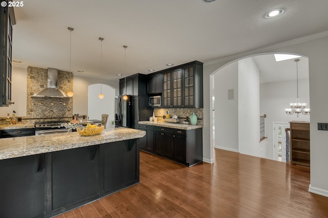 1610 Lee St, Lake Oswego, OR 97034 - kitchen featuring arched walkways, wall chimney range hood, stainless steel appliances, light countertops, and recessed lighting