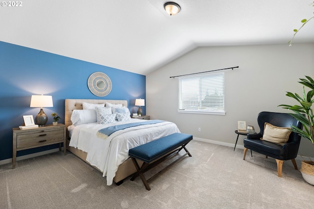 bedroom featuring baseboards, vaulted ceiling, and light colored carpet