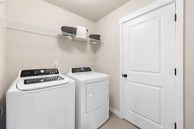 laundry area featuring baseboards, laundry area, and washing machine and clothes dryer