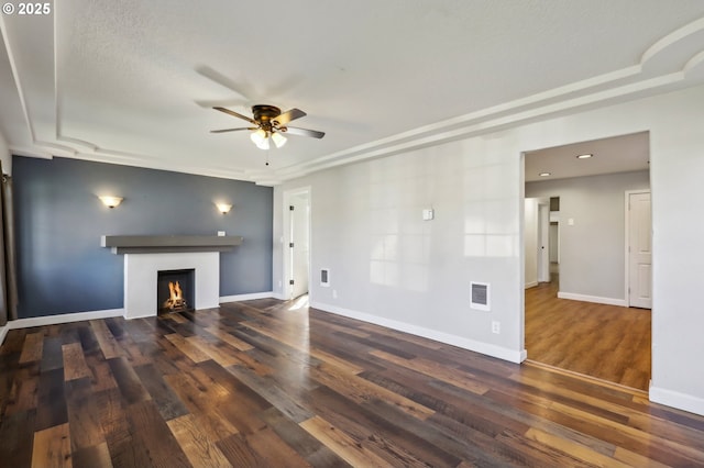 707 S 6th Ave, Kelso, WA 98626 - unfurnished living room featuring visible vents, baseboards, a ceiling fan, wood finished floors, and a warm lit fireplace