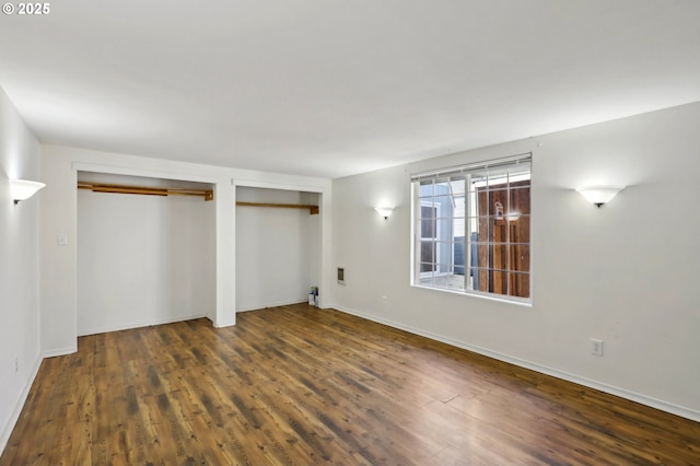707 S 6th Ave, Kelso, WA 98626 - unfurnished bedroom with wood finished floors, multiple closets, and baseboards