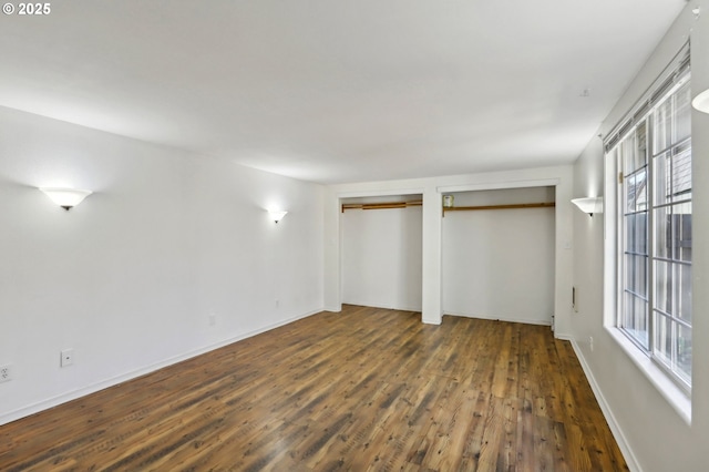 707 S 6th Ave, Kelso, WA 98626 - unfurnished bedroom with wood finished floors, multiple closets, and baseboards