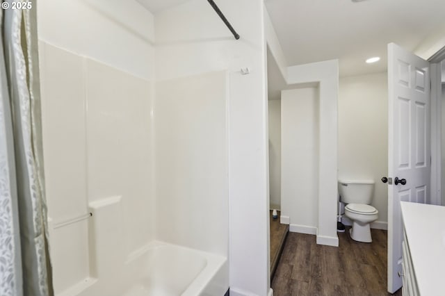 707 S 6th Ave, Kelso, WA 98626 - bathroom with wood finished floors, toilet, vanity, tub / shower combination, and baseboards