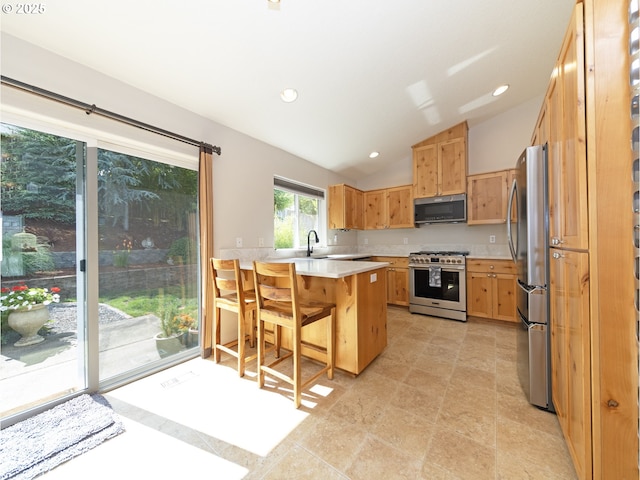 1007 4th Ave, Vernonia, OR 97064 - kitchen featuring stainless steel appliances, a peninsula, light countertops, vaulted ceiling, and a breakfast bar