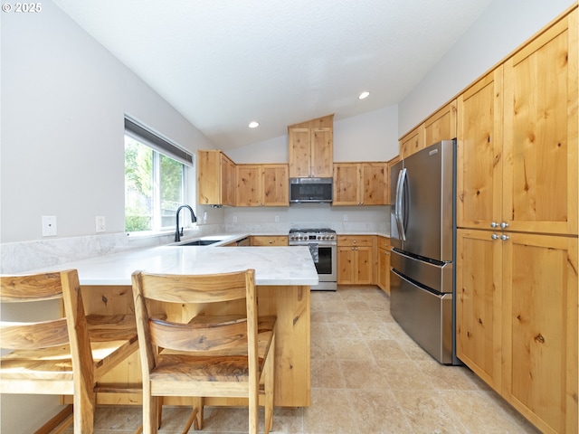1007 4th Ave, Vernonia, OR 97064 - kitchen featuring stainless steel appliances, a peninsula, vaulted ceiling, light countertops, and a breakfast bar area