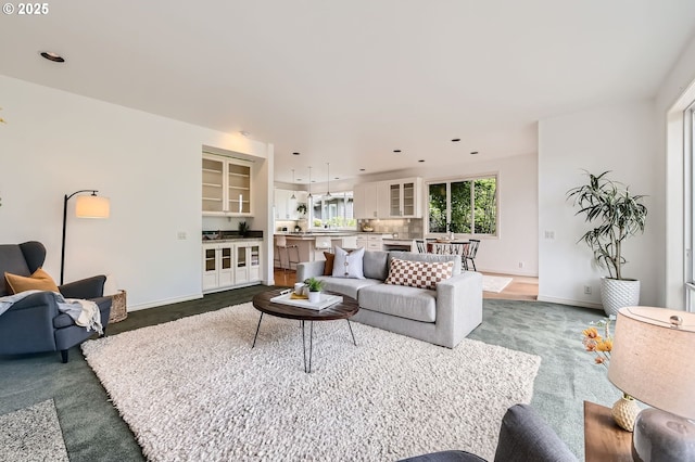 living area with recessed lighting, baseboards, and dark colored carpet
