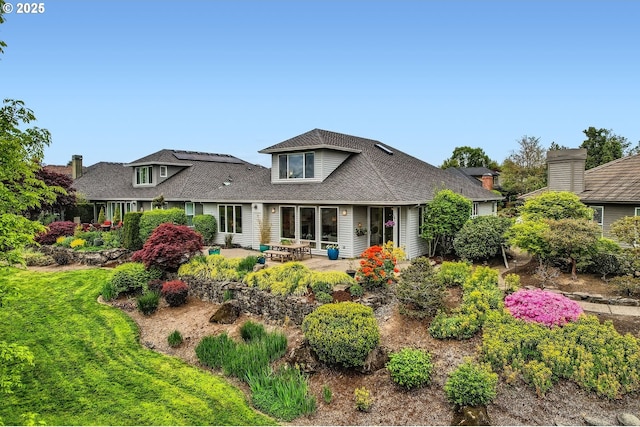 rear view of property featuring a patio area and roof with shingles