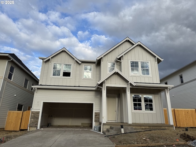 craftsman-style home featuring driveway, board and batten siding, a garage, and fence