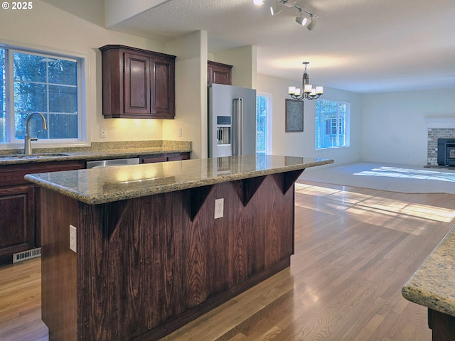 kitchen featuring stainless steel appliances, a kitchen island, sink, and hardwood / wood-style floors