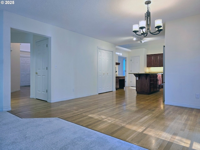 unfurnished living room featuring dark wood-type flooring and a chandelier