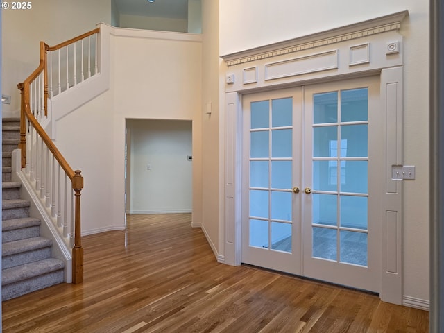 doorway to outside with hardwood / wood-style flooring, a high ceiling, and french doors