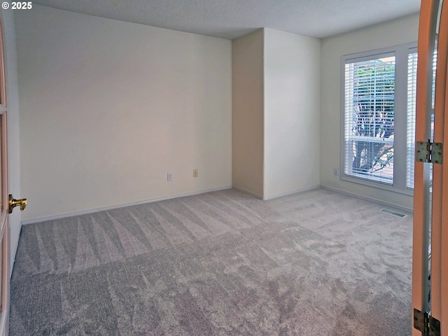 spare room featuring light colored carpet