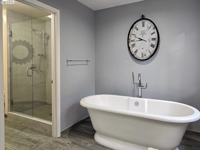 bathroom with wood-type flooring and plus walk in shower