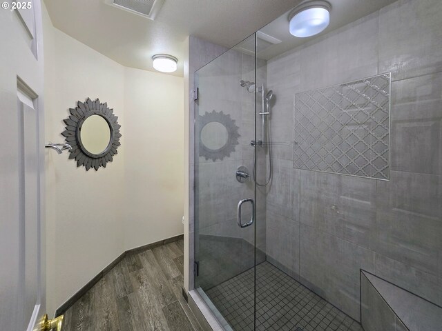 bathroom with hardwood / wood-style flooring and an enclosed shower