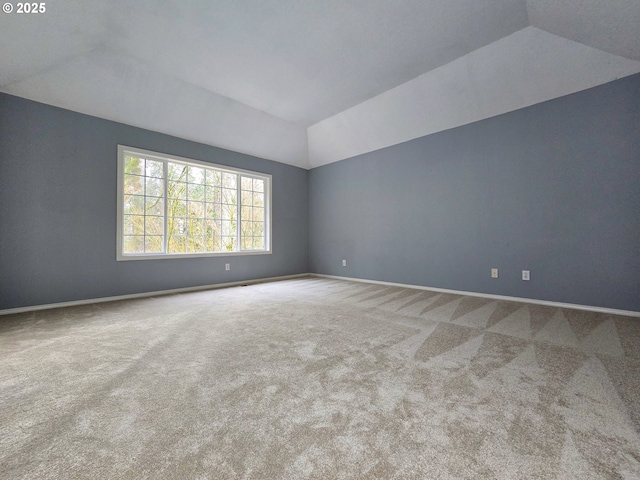 unfurnished room featuring lofted ceiling and carpet