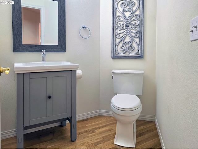 bathroom featuring hardwood / wood-style flooring, vanity, and toilet