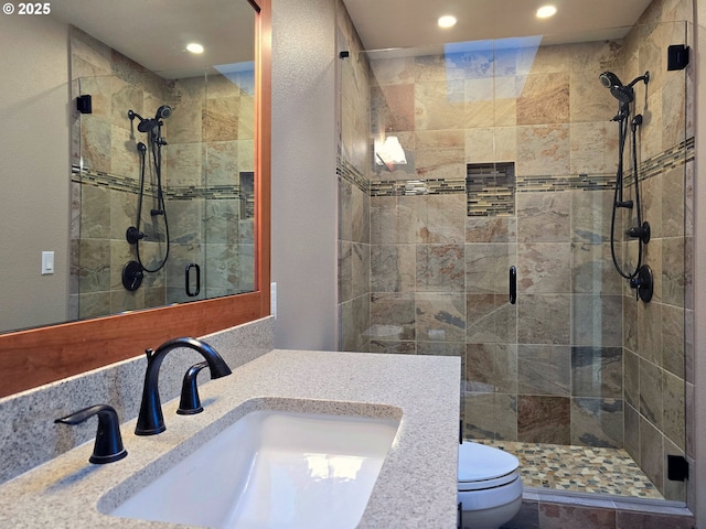 bathroom featuring vanity, toilet, and an enclosed shower