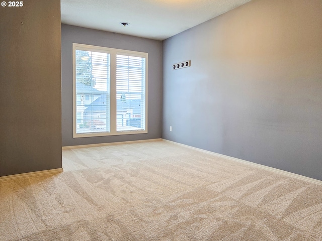 spare room featuring light colored carpet