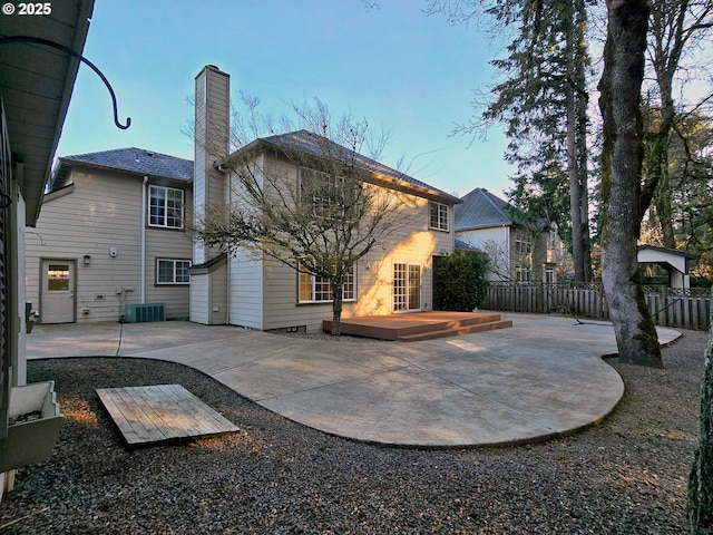 rear view of house featuring central AC, a deck, and a patio