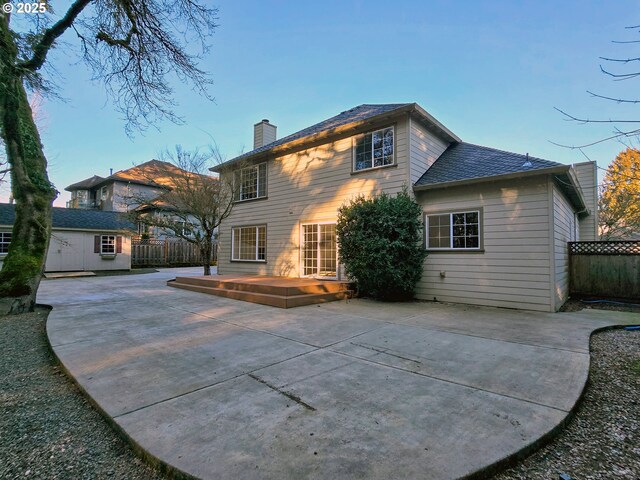 rear view of house featuring a patio area, a deck, and a shed