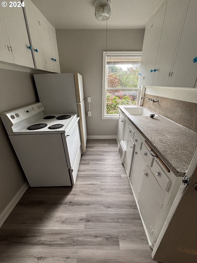 646 SE 60th Ave, Portland, OR 97215 - kitchen with baseboards, white electric range oven, a sink, and white cabinets