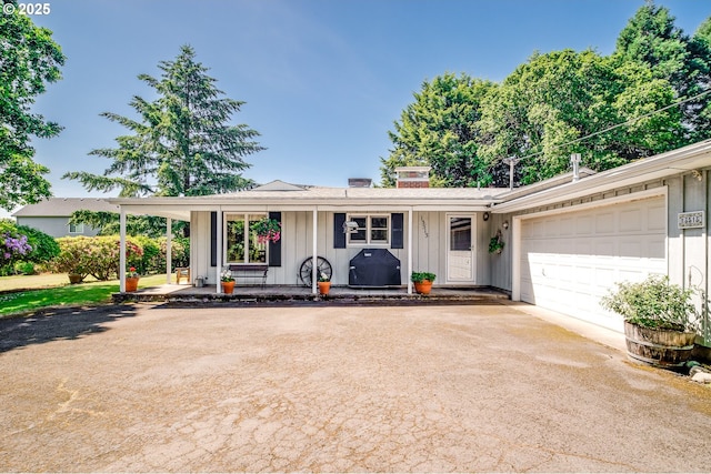 13513 SE 132nd Ave, Clackamas, OR 97015 - ranch-style home featuring board and batten siding, covered porch, driveway, an attached garage, and a chimney