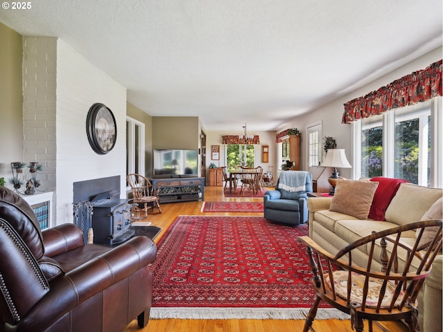 13513 SE 132nd Ave, Clackamas, OR 97015 - living area featuring wood finished floors, a wood stove, a chandelier, and a textured ceiling