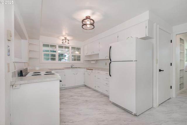 kitchen with white cabinetry, sink, and white fridge