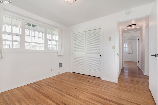 unfurnished bedroom with a closet and light wood-type flooring