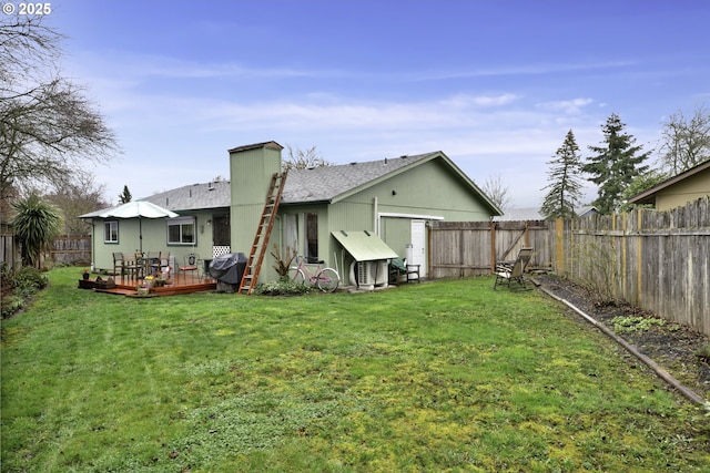 rear view of property with a deck, a yard, a fenced backyard, and roof with shingles