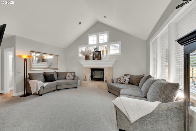 living area featuring high vaulted ceiling, baseboards, carpet, and a tiled fireplace