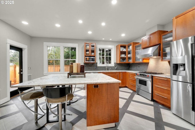 kitchen featuring under cabinet range hood, recessed lighting, appliances with stainless steel finishes, and a kitchen island