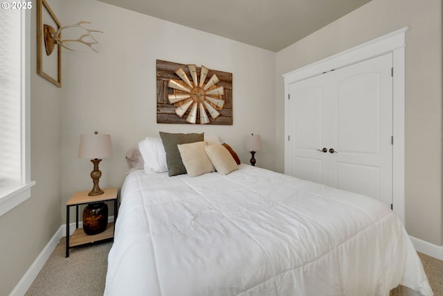 bedroom with a closet, baseboards, and carpet