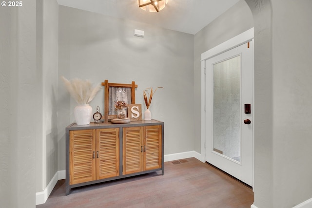 entrance foyer with visible vents, baseboards, and wood finished floors