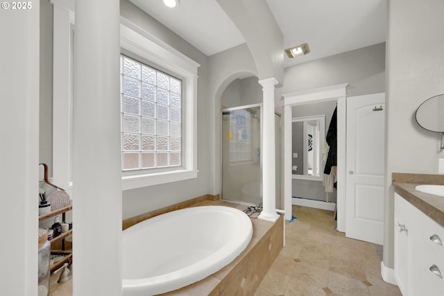 full bath featuring vanity, a shower stall, a bath, and ornate columns